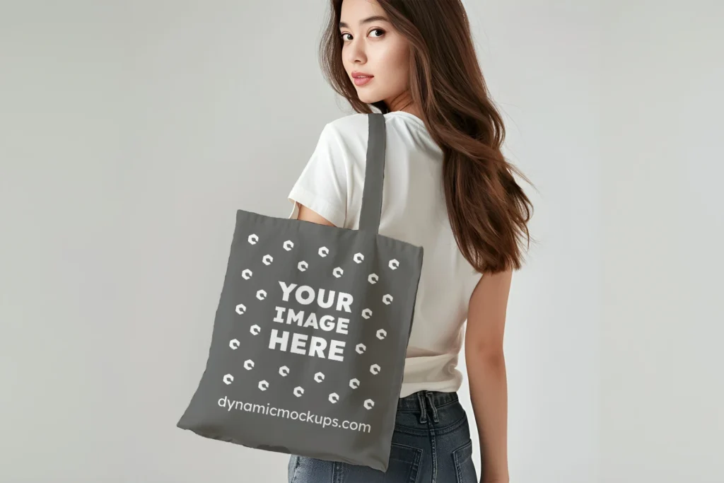 Woman Holding Dark Gray Tote Bag Mockup Back View Template