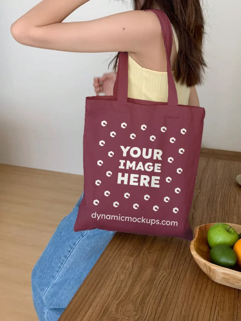 Woman Holding Maroon Tote Bag Mockup Side View Template