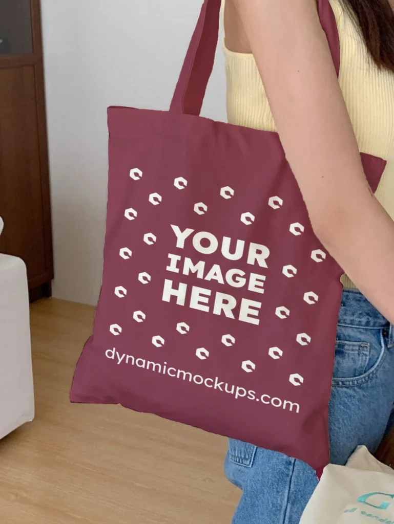 Woman Holding Maroon Tote Bag Mockup Side View Template