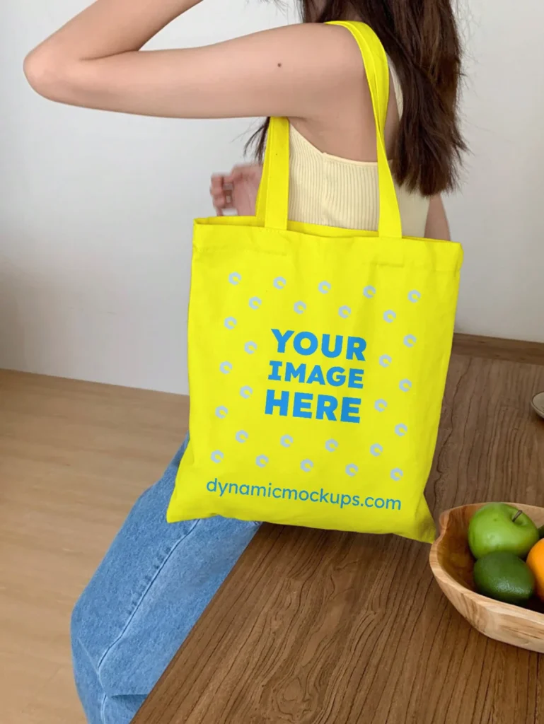 Woman Holding Yellow Tote Bag Mockup Side View Template